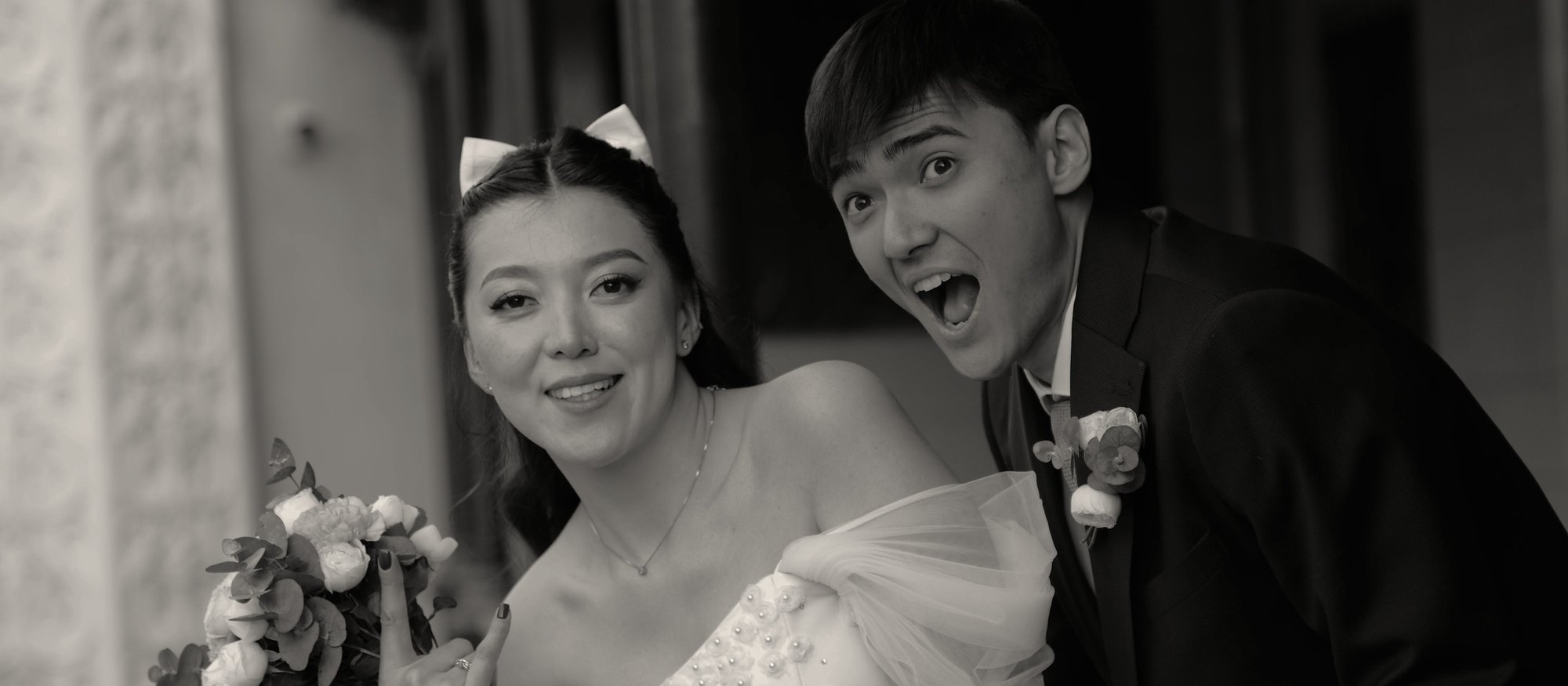 Bride and groom leaning in together, laughing at the camera